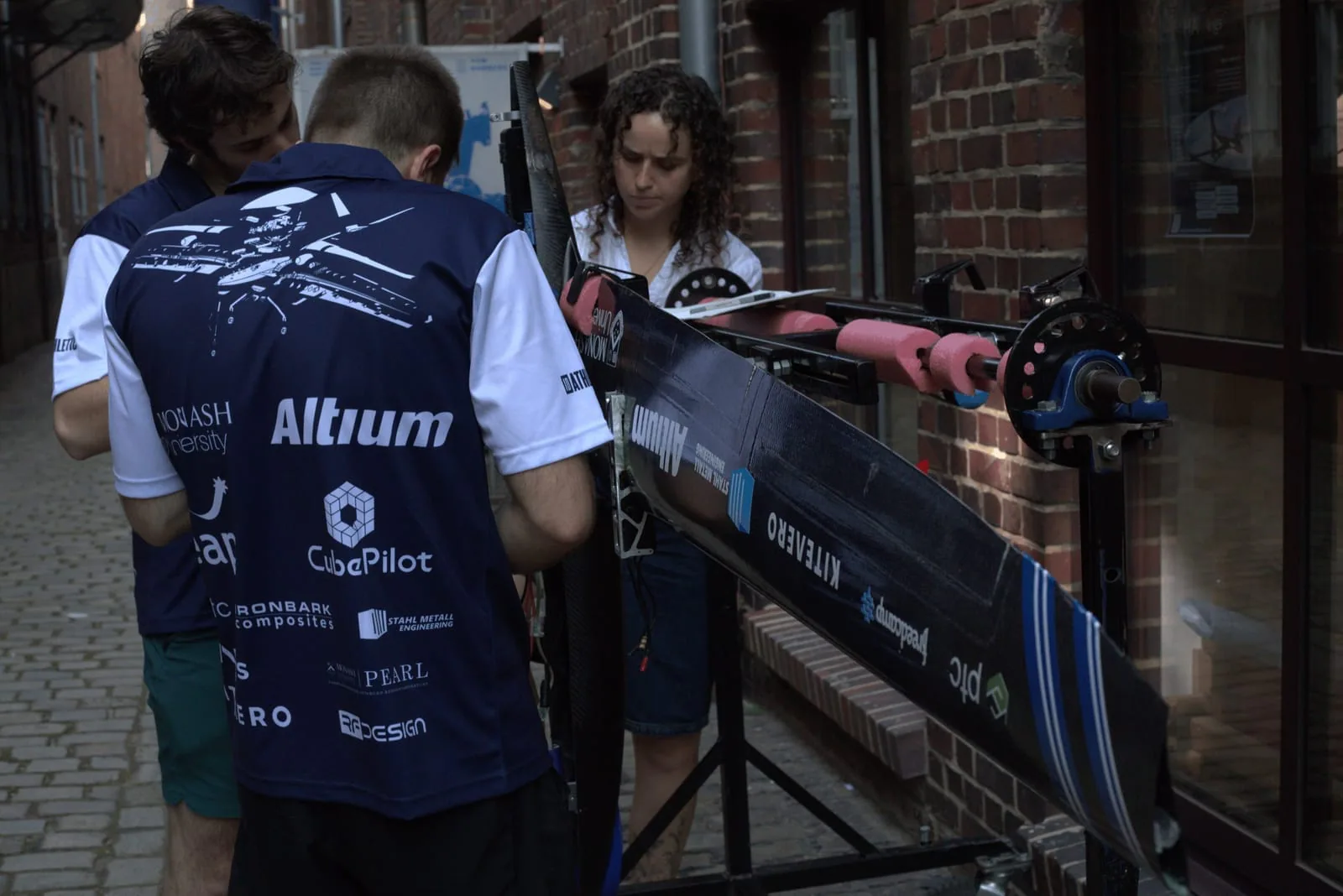 MUAS students preparing an uncrewed aircraft with sponsor logos visible